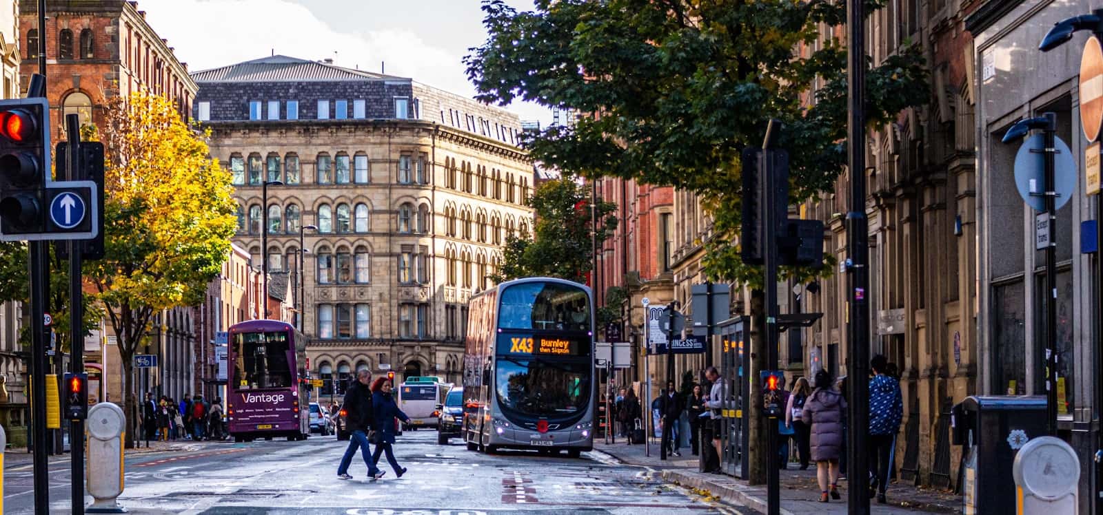 Shoppers on a Manchester street beside a brick building